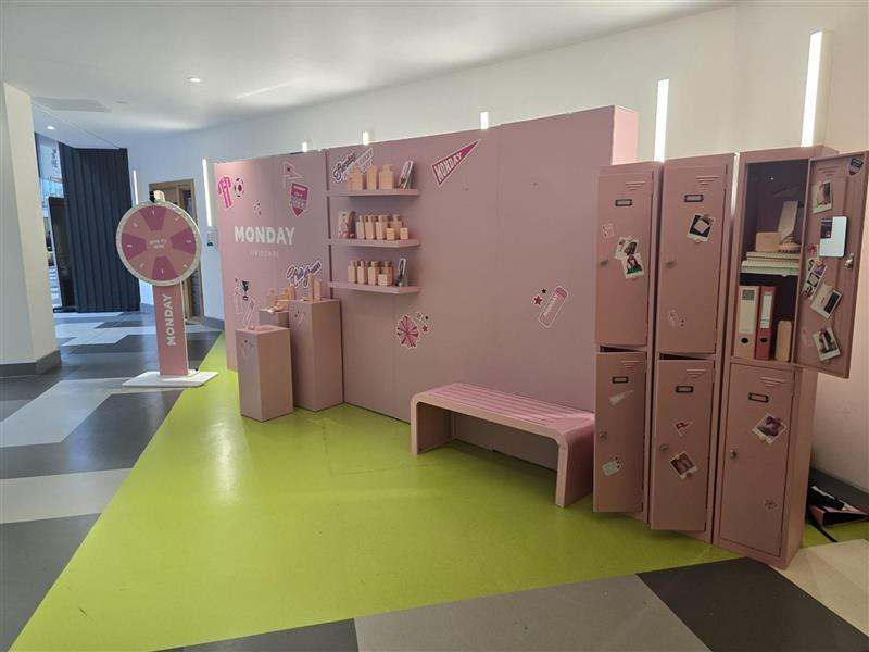 A Monday stall with pink lockers and a spinning wheel