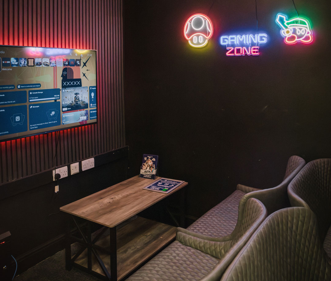 A gaming zone with neon Mario signs on the wall